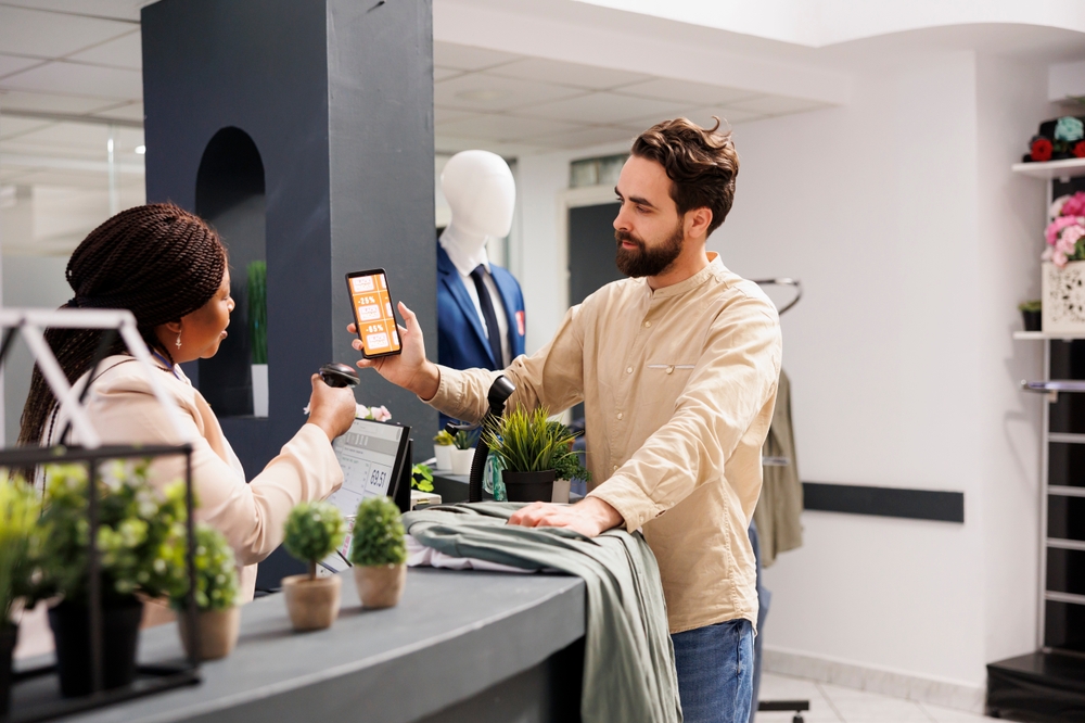 Customer using a digital loyalty app on their mobile in a clothes store