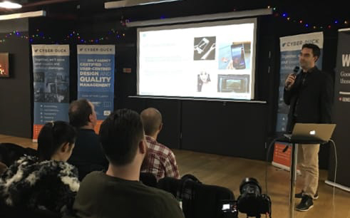 Photo of CDO Sylvain giving a slideshow presentation in front of a crowd